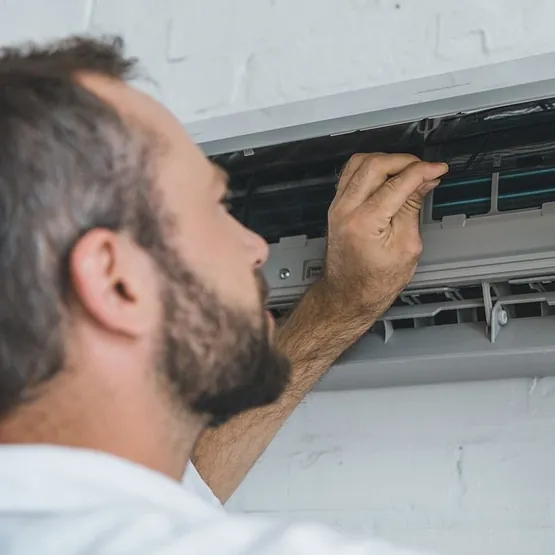 hombre abre aparato de aire acondicionado